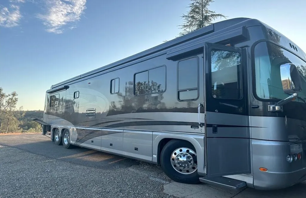 Luxury Class A diesel pusher motorhome parked in a Northern California driveway before mobile CARB testing