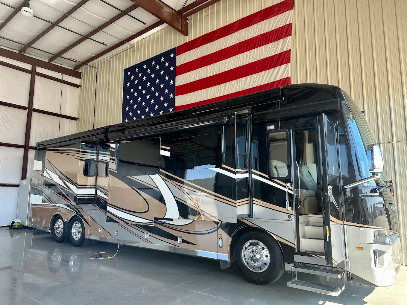 Newmar Dutch Star luxury diesel motorhome staged for a mobile CARB Clean Truck Check, with an American flag backdrop
