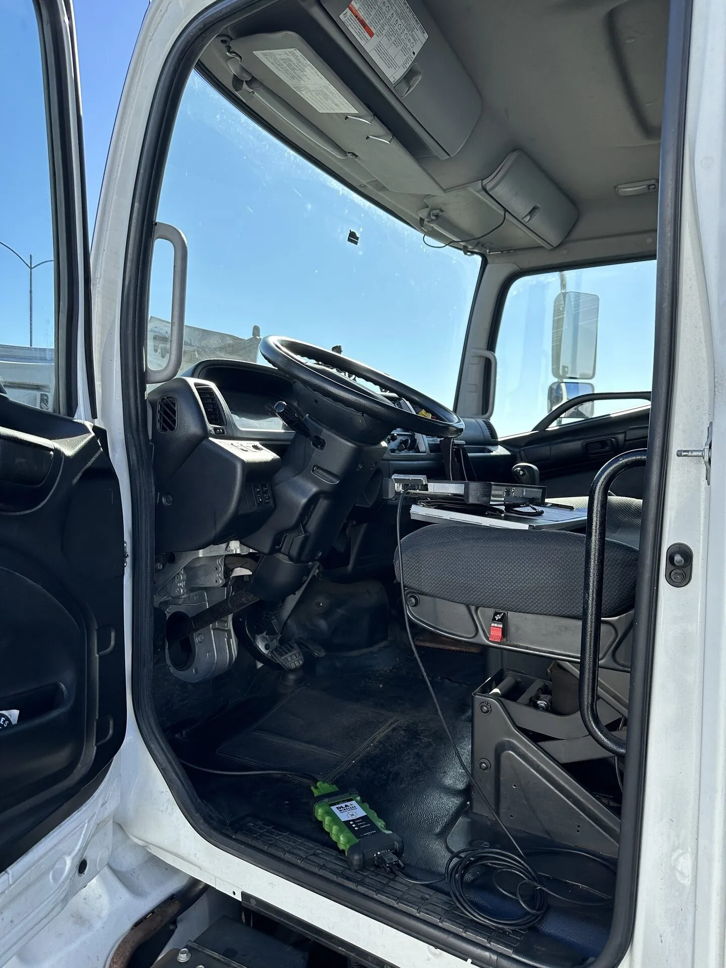 OBD-II scanner connected inside a heavy-duty truck cab during a CARB Clean Truck Check